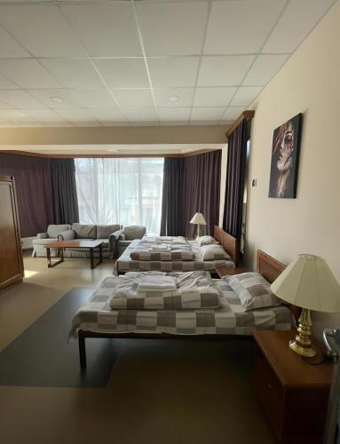 a hotel room with two beds and a couch at DownTown Guest House in Vanadzor