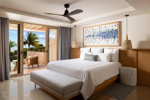 a bedroom with a large white bed and a balcony at Secrets Playa Mujeres Golf & Spa Resort - All Inclusive Adults Only in Cancún