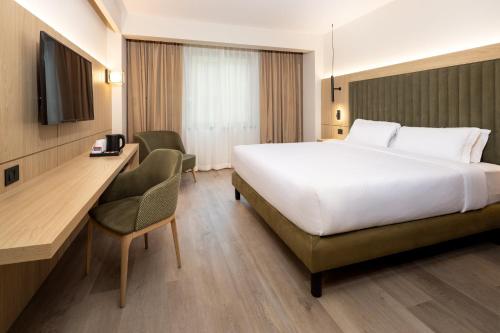 a hotel room with a large bed and a desk at Holiday Inn Naples by IHG in Naples
