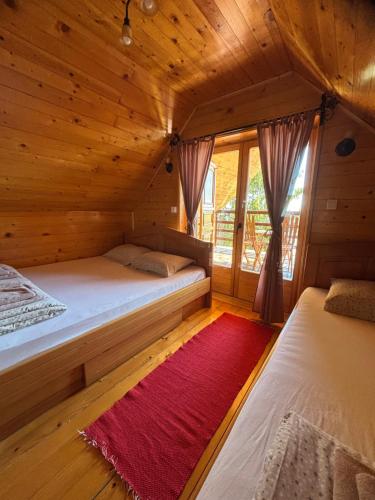a bedroom with two beds in a wooden cabin at Apartman Tri srca Zlatar in Nova Varoš