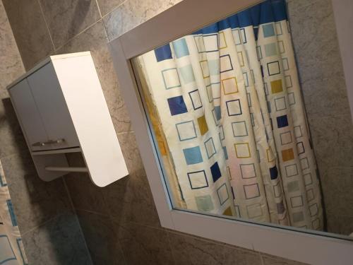 a bathroom mirror with a reflection of a building at Los Nonos in Perdriel