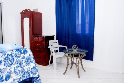 a bedroom with a bed and a table and a chair at Sharays Hideaway in Bull Bay