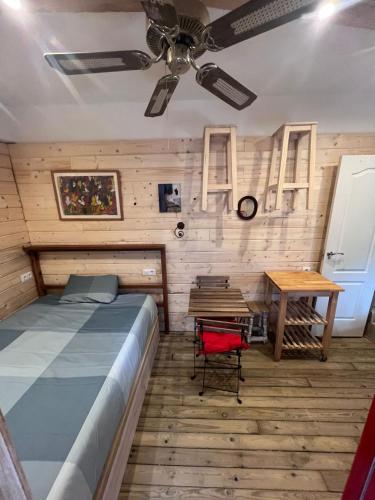 a bedroom with a bed and a table and a ceiling fan at El estudio de César in Conil de la Frontera