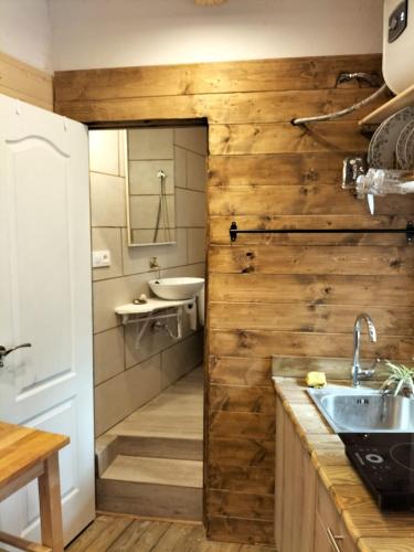 a bathroom with a wooden wall and a sink at El estudio de César in Conil de la Frontera