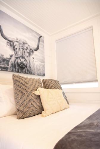 a bedroom with a cow painting on the wall at NEW! Cozy Container Home at Cliffside #3 in Orderville