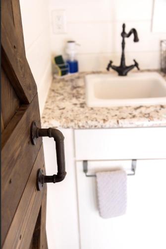 a bathroom with a sink and a wooden door at NEW! Cozy Container Home at Cliffside #3 in Orderville