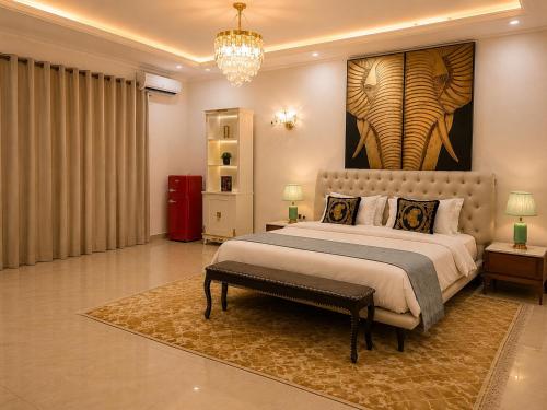 a bedroom with a large bed with a painting on the wall at Maria Gracia House in Grand-Bassam