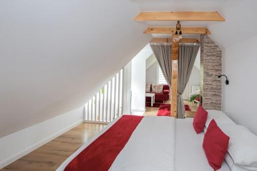 a bedroom with a white bed with red pillows at The Nest Apartment in Sovata