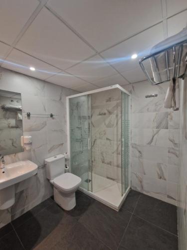 a bathroom with a shower and a toilet and a sink at Hostal Lizana 2 in Huesca