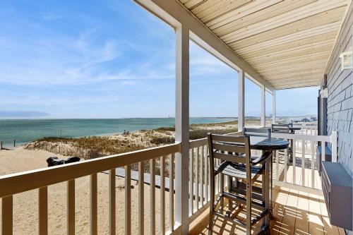 a balcony with a table and a view of the beach at Oceanfront suite with bay views full kitchen balcony AC & firepit in North Truro