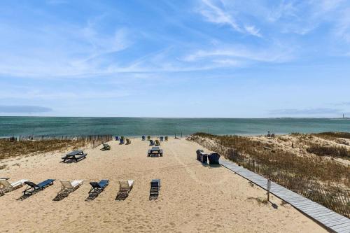 a group of beach chairs on a sandy beach at Oceanfront suite with bay views full kitchen balcony AC & firepit in North Truro