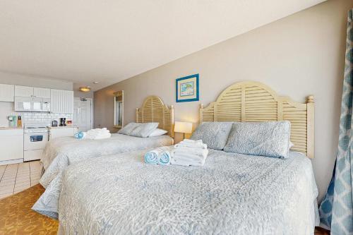 a bedroom with two beds and a kitchen at Oceanfront getaway with Bay-view balcony full kitchen AC in North Truro