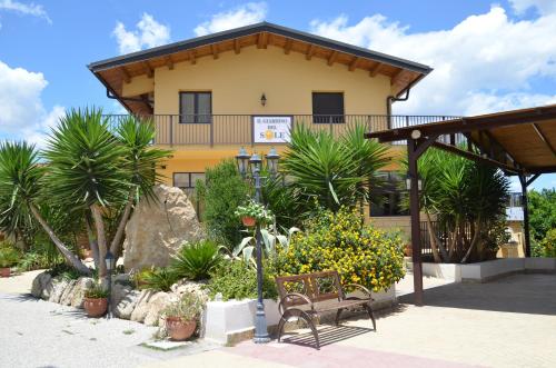 a bench in front of a building with plants at Il Giardino Del Sole in Agnone Bagni