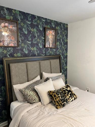 a bedroom with a large bed with leopard pillows at Philly Content House in Marcus Hook