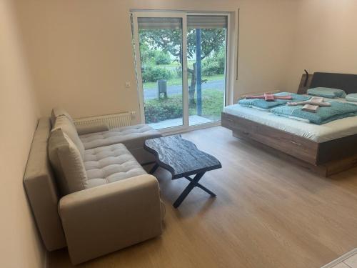 a bedroom with a couch and a bed and a window at Stay Zentral Dresden in Dresden
