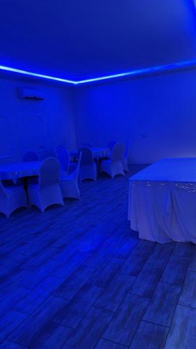 a room with white tables and chairs and blue lights at استراحة لايك لاين ديراب in Ar Riyāḑ