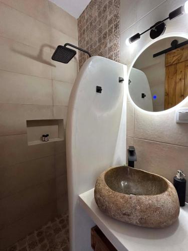 a bathroom with a stone sink and a mirror at Babatseratsi 3 Apartment in Skiros
