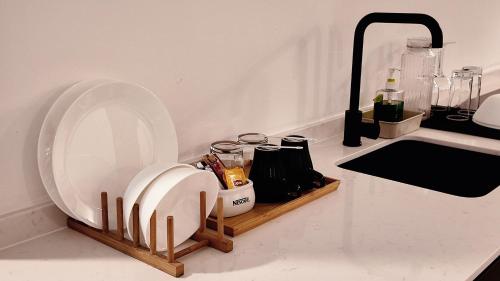 a kitchen counter with a plate on a wooden shelf at Thy Executive Hotel in Johor Bahru