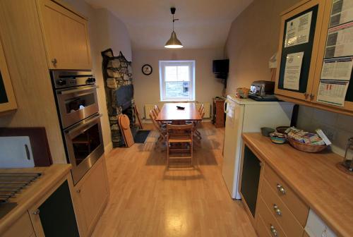 a kitchen with a table and a dining room at The Eagles Bunkhouse in Betws-y-coed