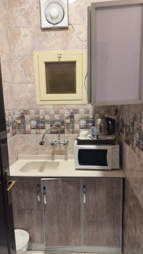 a kitchen with a sink and a microwave at Zahraa Al-Tal in Baljurashi