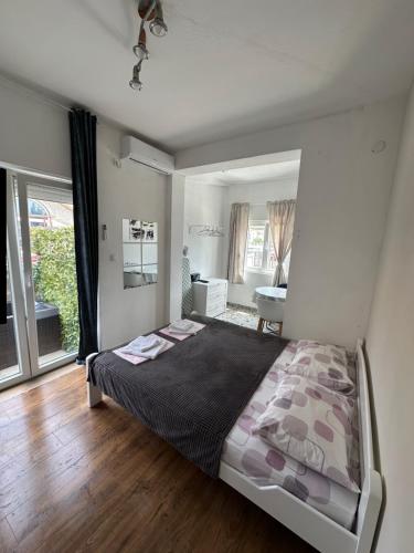 a bedroom with a bed and a large window at AK mini studio u centru in Tivat