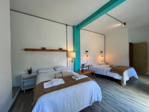 a room with two beds in a room at La Tozi Hotel in San Cristóbal de Las Casas