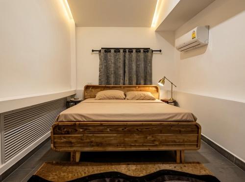 a bedroom with a wooden bed in a room at Nirvana By the Sea in Ban Madua Wan