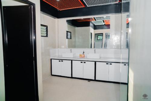 a bathroom with two sinks and a mirror at Luna Vista Tourist Inn in Puerto Princesa City