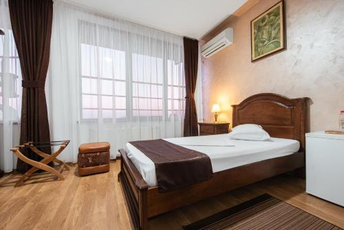 a bedroom with a bed and a large window at Hotel Rion in Mangalia