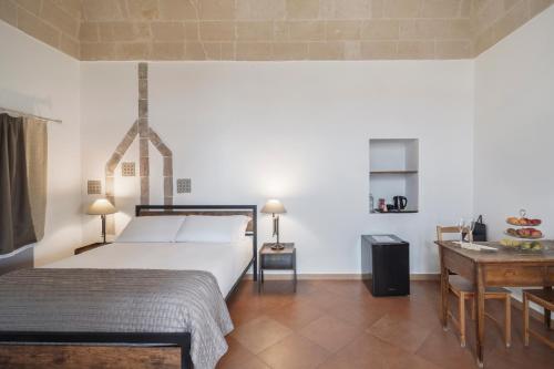 a bedroom with a bed and a table and a desk at Dimora Santa Barbara in Matera