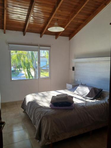 a bedroom with a bed and a large window at Cabaña Alberto in Balneario Claromecó
