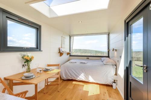 a bedroom with a bed and a table and windows at 1 Bed in Ponsonby oc-l37879 in Gosforth
