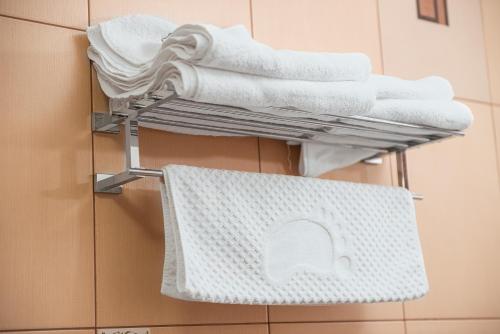 a pile of towels on a towel rack in a bathroom at Hotel Rion in Mangalia