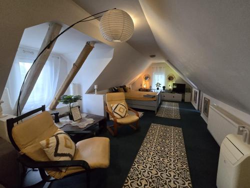 a living room with an attic with chairs and a table at Atia Residence in Sibiu
