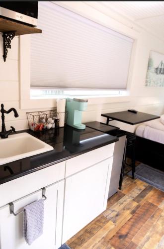 a kitchen with white cabinets and a sink at NEW! Cozy Container Home at Cliffside #5 in Orderville