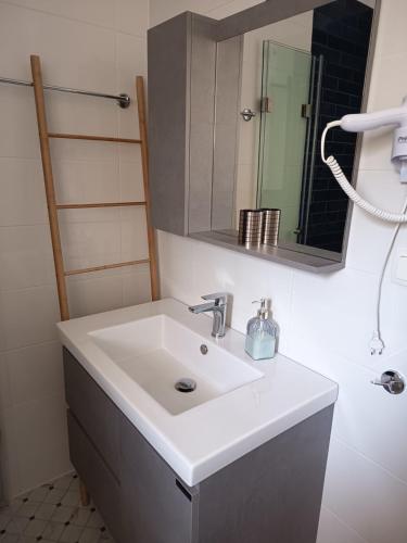 a bathroom with a white sink and a mirror at Apartment2-Rosanna in Plataria