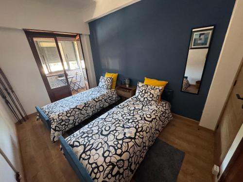 a bedroom with two beds and a mirror on the wall at Margem Rio Residence in Sacavém