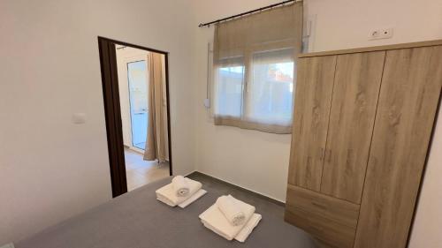 a bedroom with two white towels sitting on a bed at Anemos Comfort Living in Paralia Panteleimonos