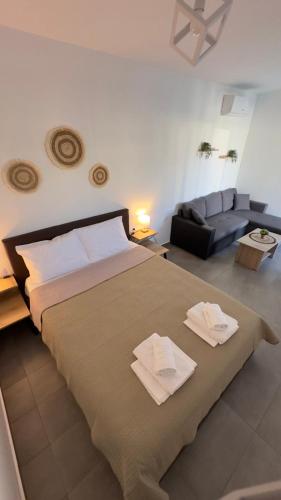 a bedroom with a large bed and a couch at Anemos Comfort Living in Paralia Panteleimonos
