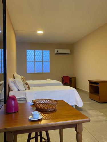 a hotel room with a bed and a table with a table sidx sidx at Loft Campinho 1 in Estação Inhoaíba