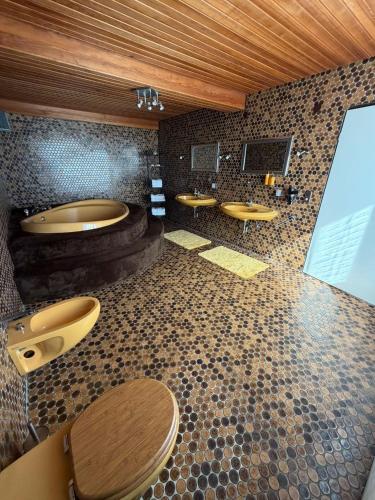 a bathroom with two sinks and a tub and toilets at Ferienhaus Hofgut von Schaewen in Waldesch