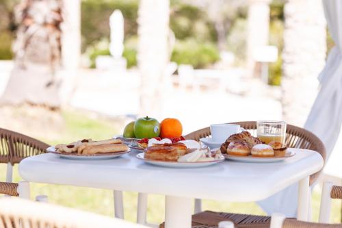 a white table with plates of food on it at Masseria Tenuta Specolizzi in Lido Marini