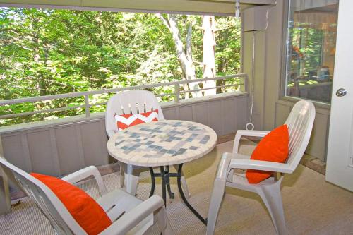 a porch with a table and two chairs and a table at Hawks Nest 27 in Glen Arbor