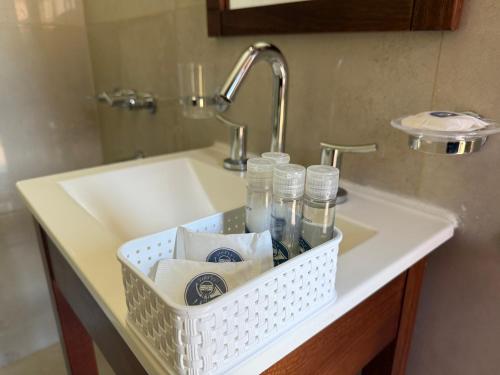 a white basket on a sink in a bathroom at Complejo Foecyt Santa Fe in Colastiné
