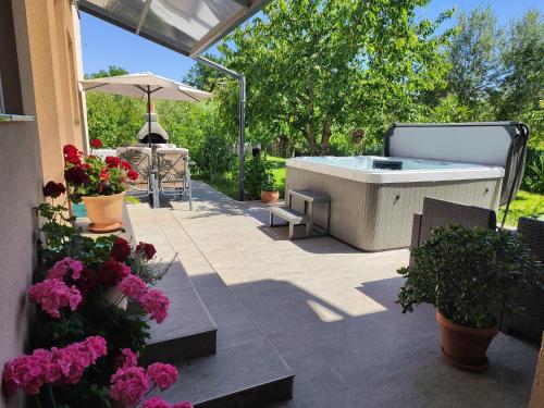 a patio with a hot tub and some flowers at Rooms Katarina in Poreč