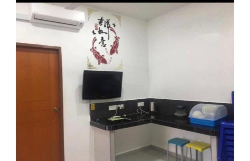 a room with a desk and a tv on the wall at LCS Homestay in Pangkor