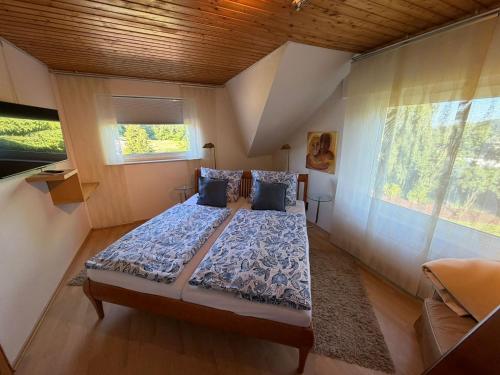 a bedroom with a bed and a large window at Ferienhaus Hofgut von Schaewen in Waldesch
