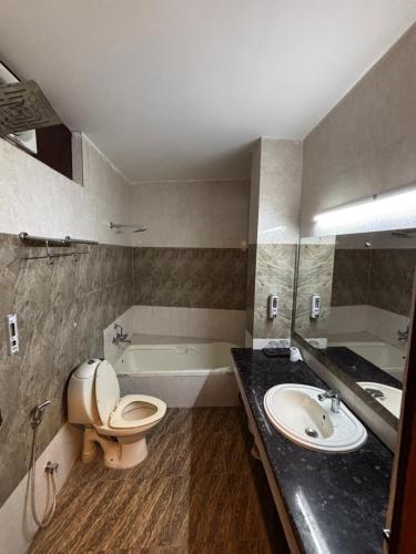 a bathroom with a toilet and a sink and a tub at Hotel heritage luxeevista in Tājganj