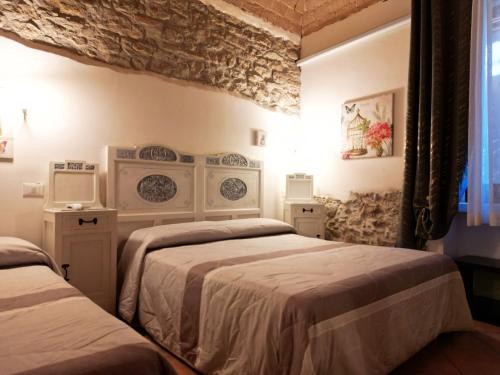 a bedroom with two beds and a stone wall at Masseria La Guardata in Guglionesi