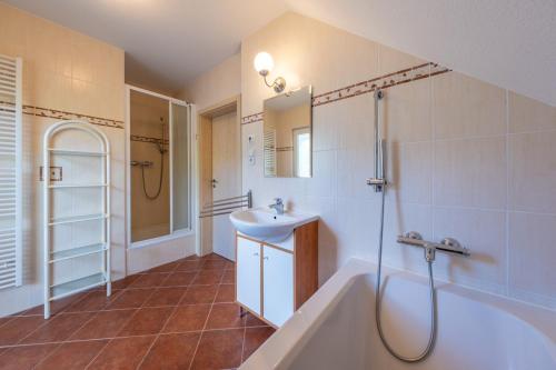 a bathroom with a tub and a sink and a shower at Villa Gamma - Lipno Home in Lipno nad Vltavou